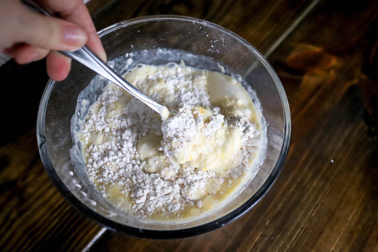 Hand with a fork whisking together basic pancake batter.