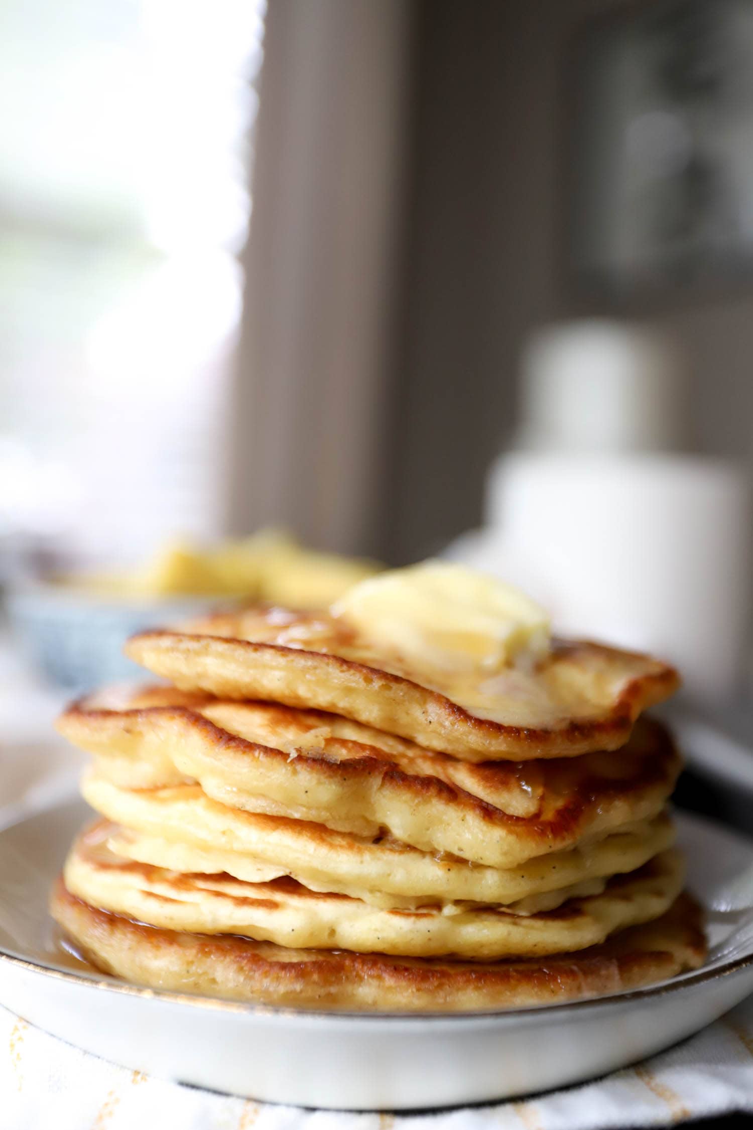 Stack of everyday pancakes with butter melting over top.