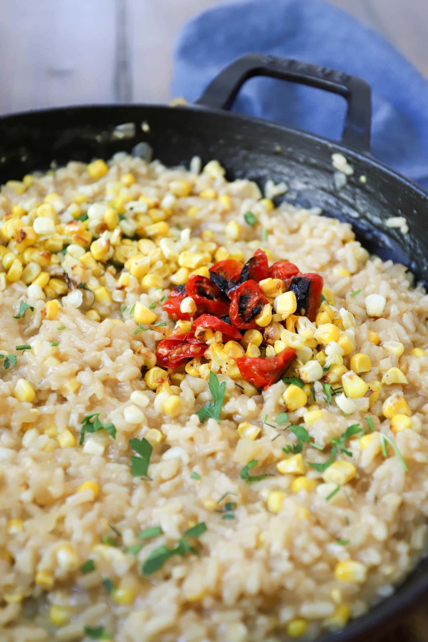homemade corn risotto with blistered cherry tomatoes topped with fresh herbs