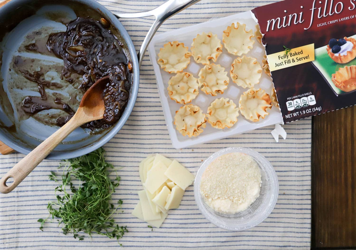 Ingredients for caramelized onion phyllo cups appetizer on white striped cloth.