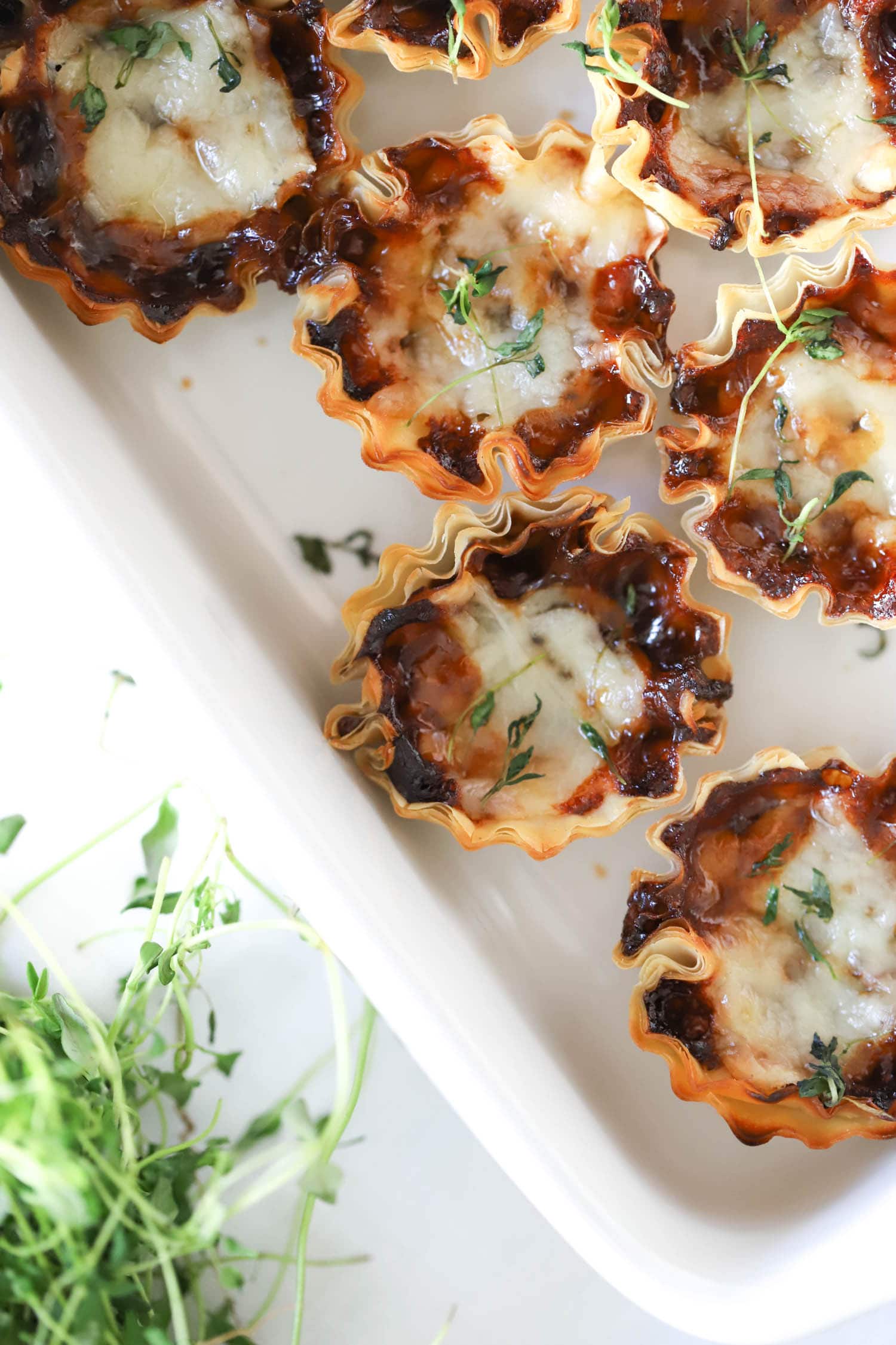 Top view of phyllo cups topped with fresh thyme leaves.