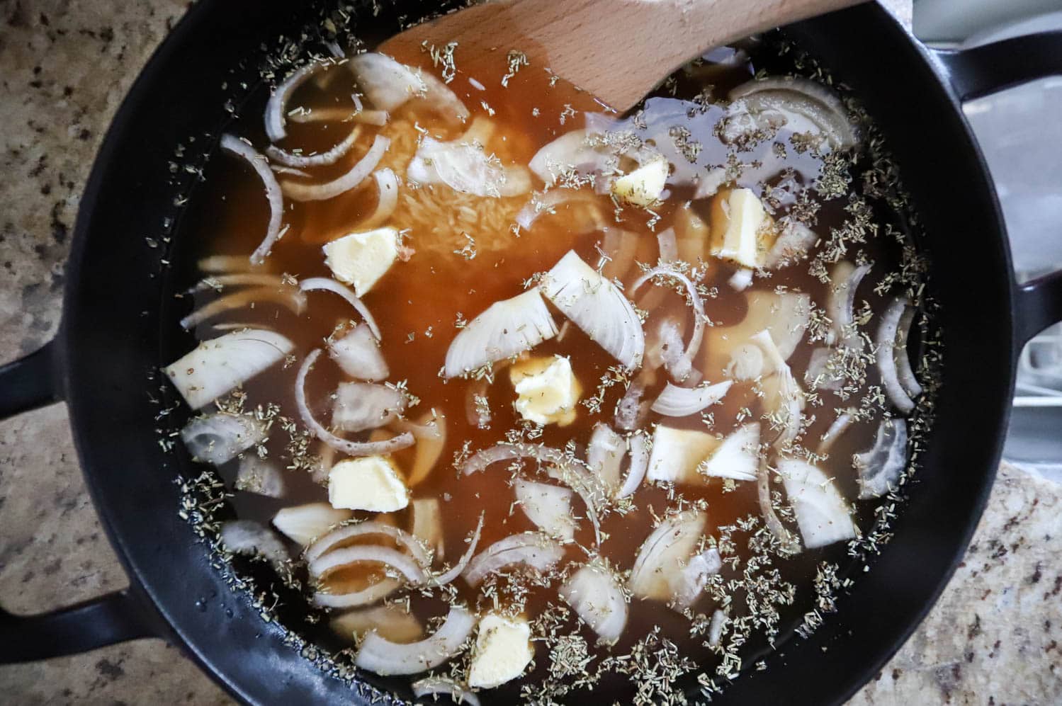 uncooked broth and sliced onions in a large skillet.