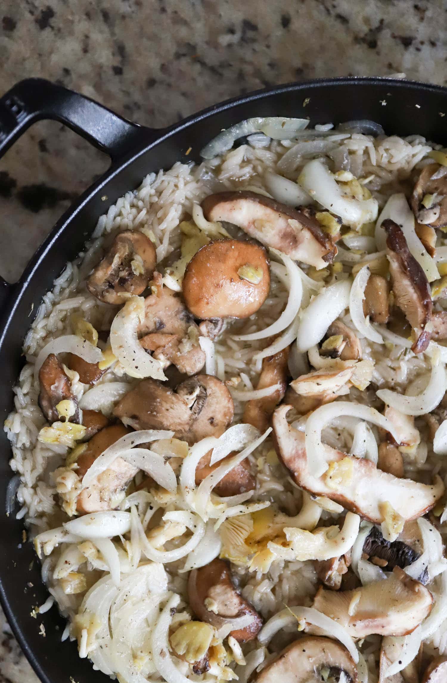 uncooked mushrooms over rice in a large baking dish.