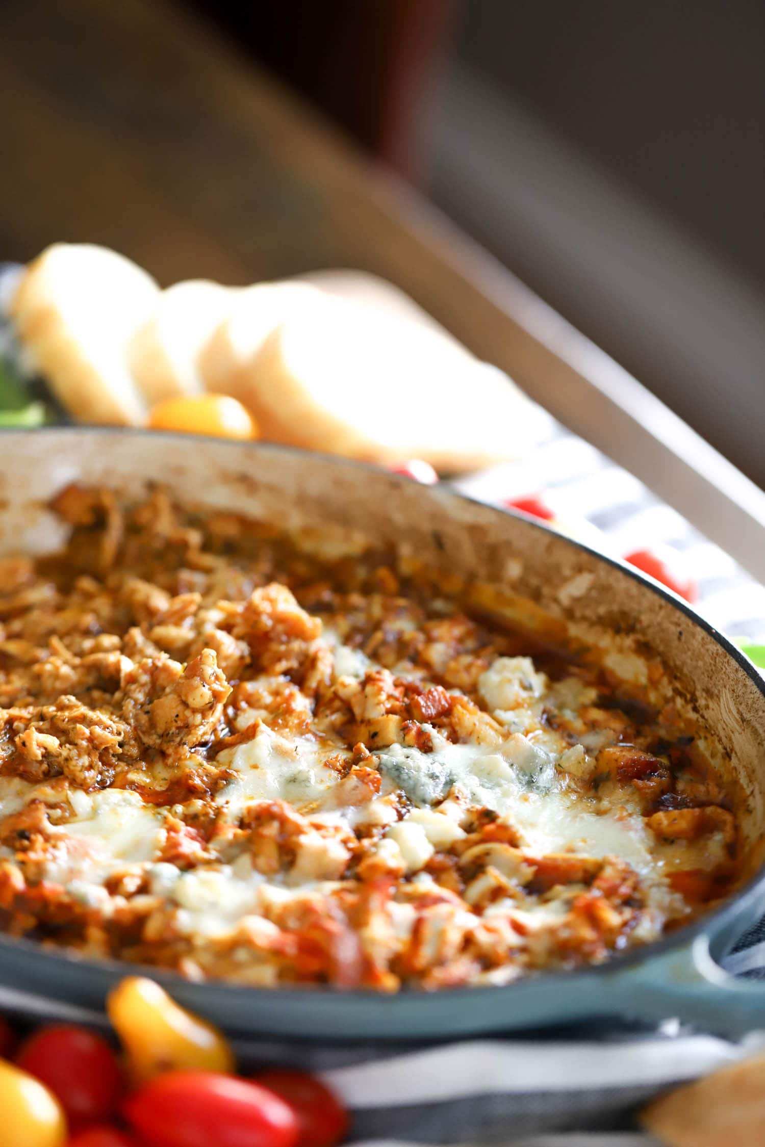 side view of buffalo chicken skillet topped with blue cheese.