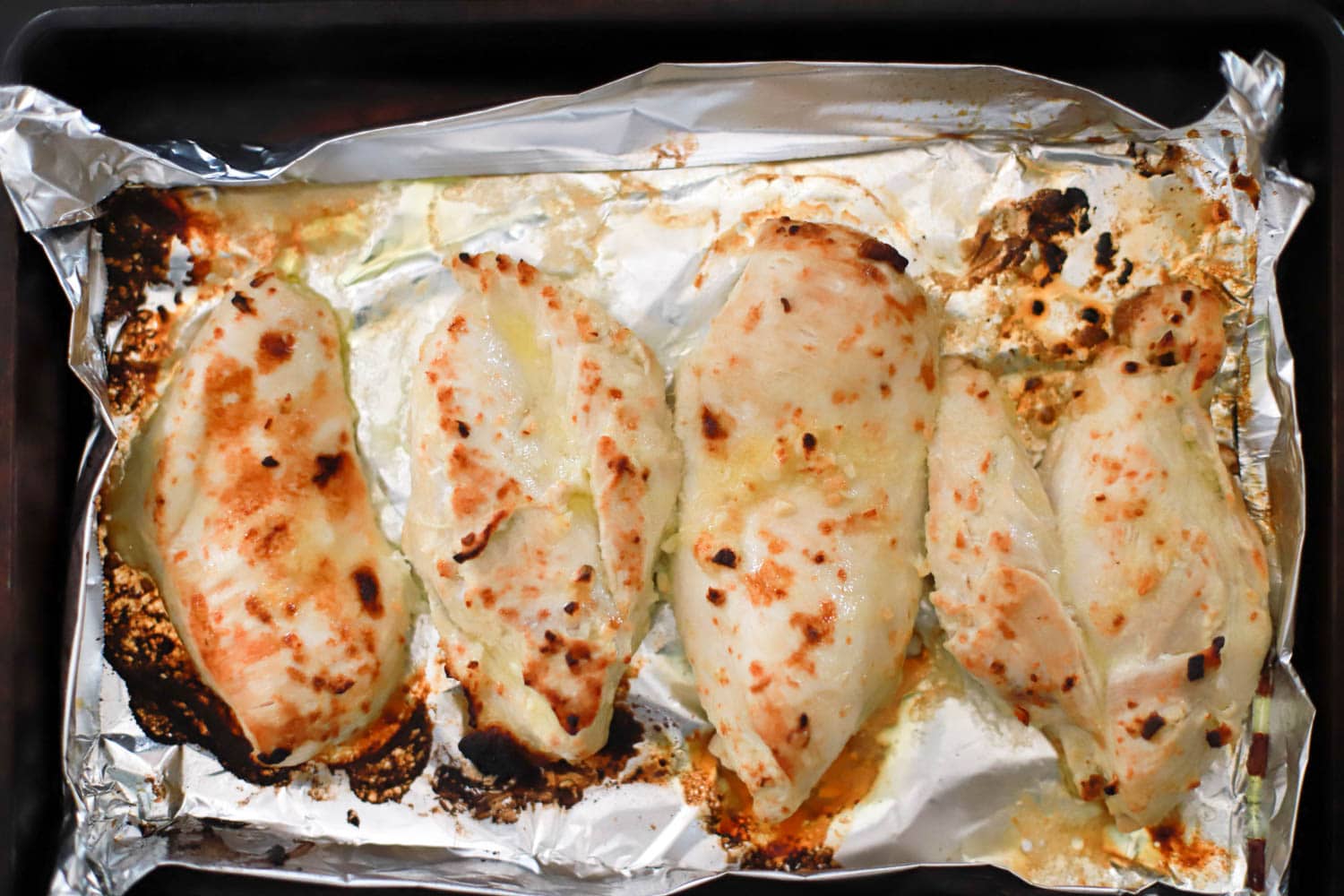 broiled chicken breasts with garlic lemon marinade on sheet pan with aluminum foil