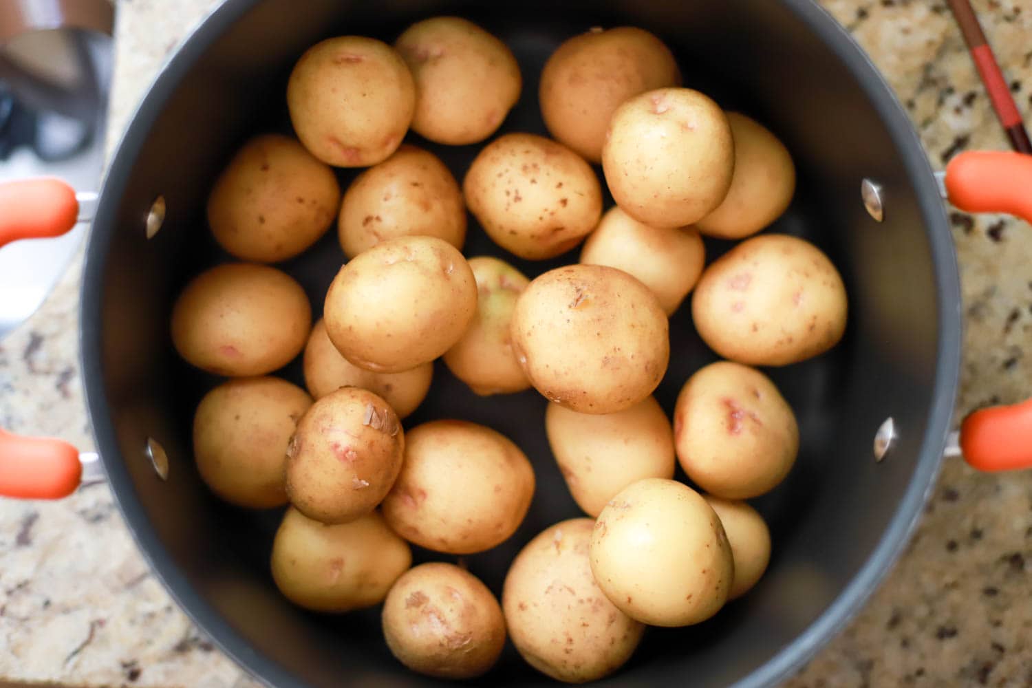 black pot of tiny potatoes before being boiled.