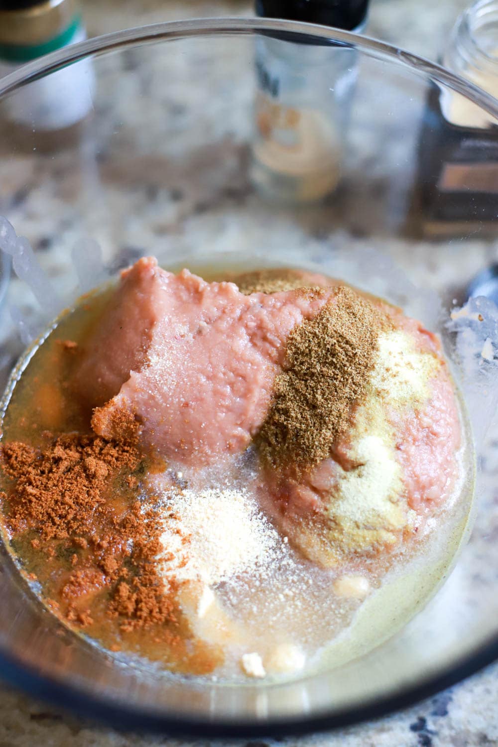 Glass bowl with refried beans for hot bean dip and spices.