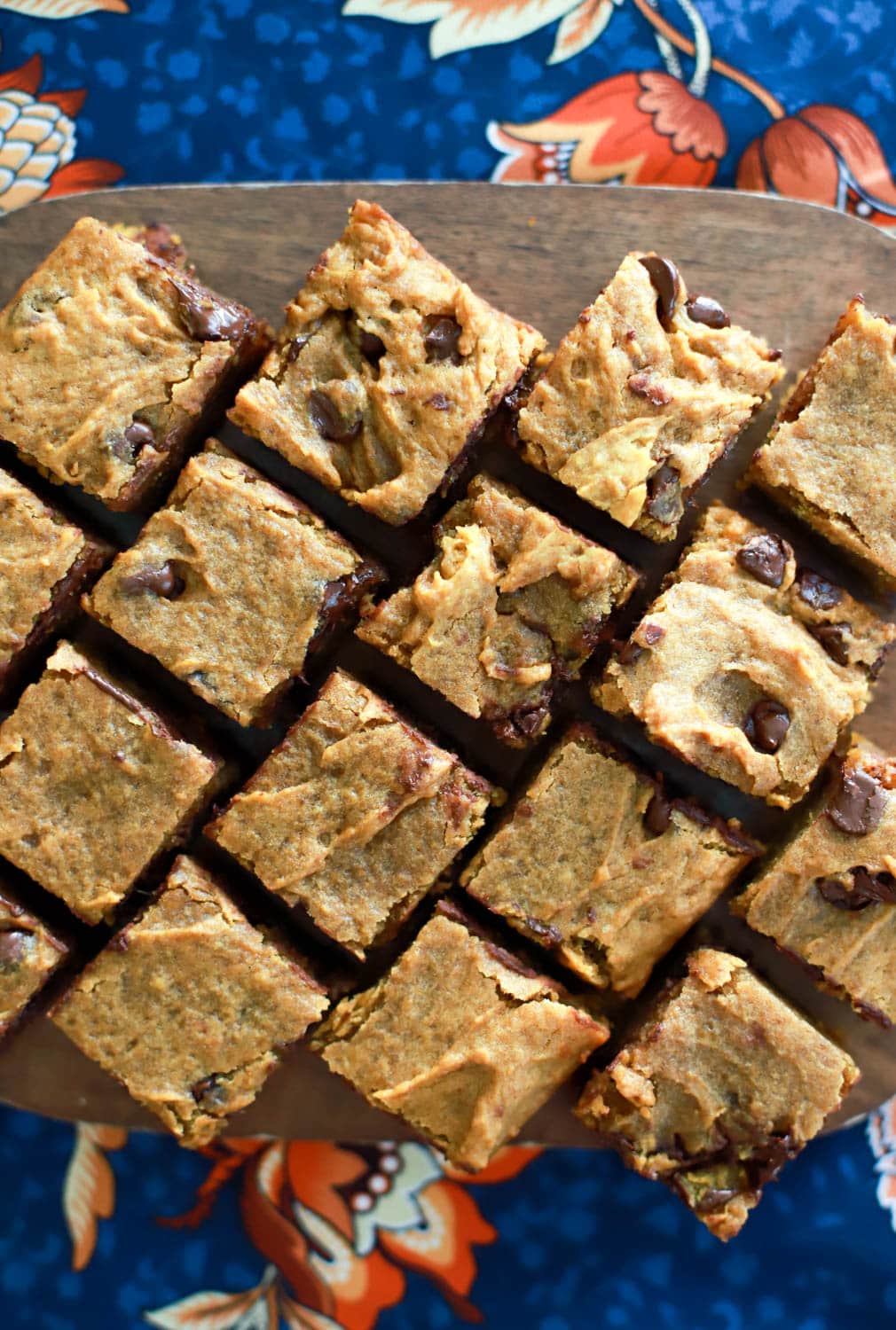 rows of cut pumpkin blondies on wooden serving board.