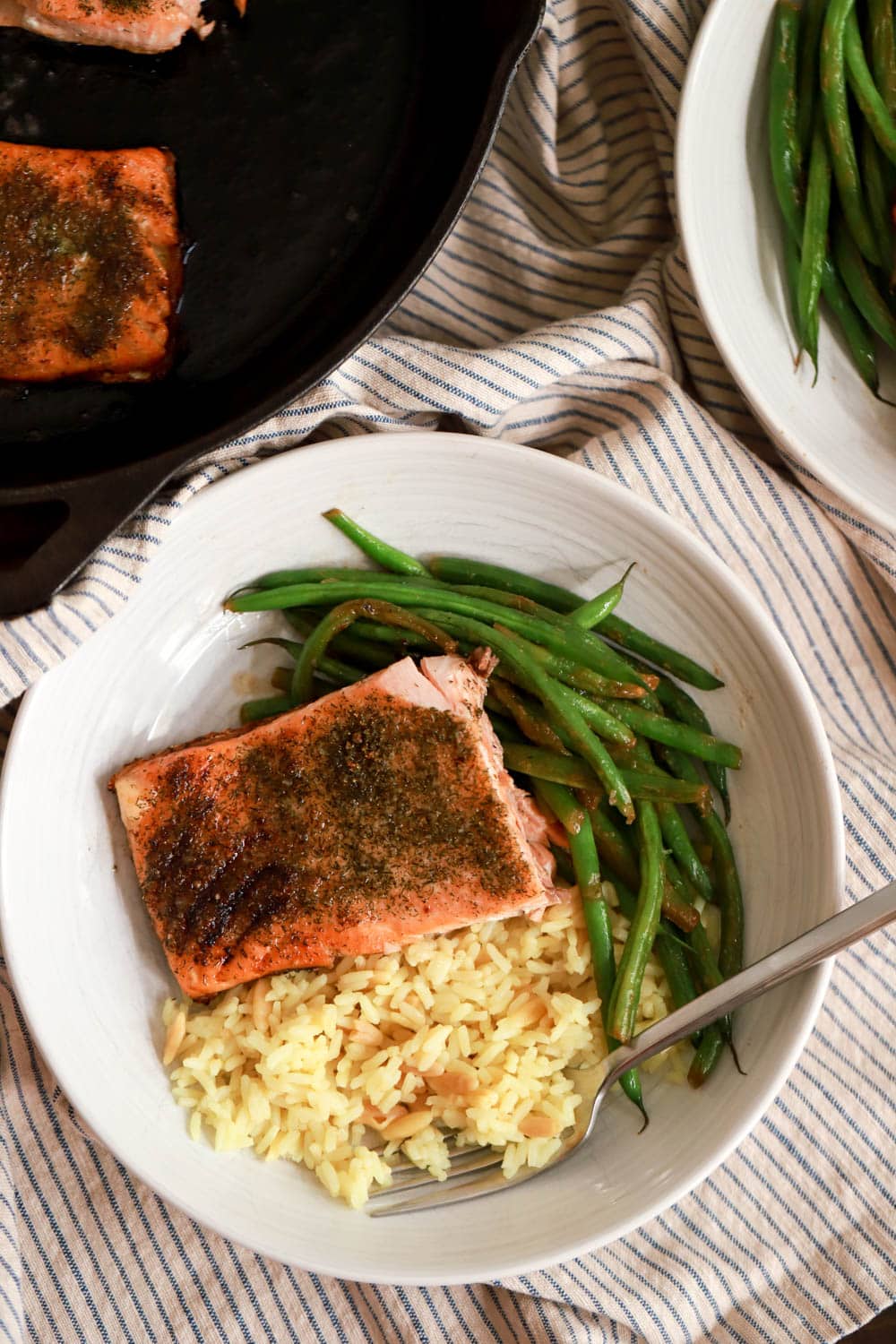 plate of pan seared salmon with rice and green beans on napkin