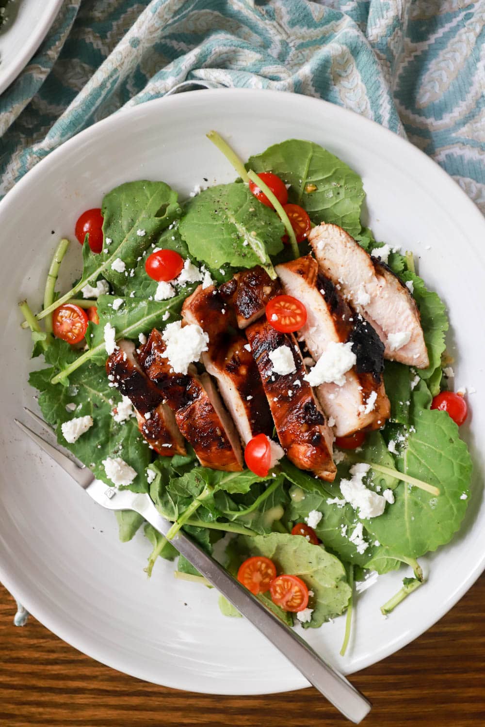 White bowl with salad, grilled chicken, and tomatoes.