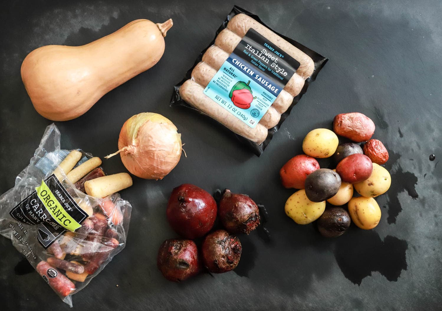 sheet pan dinner ingredients on black board.