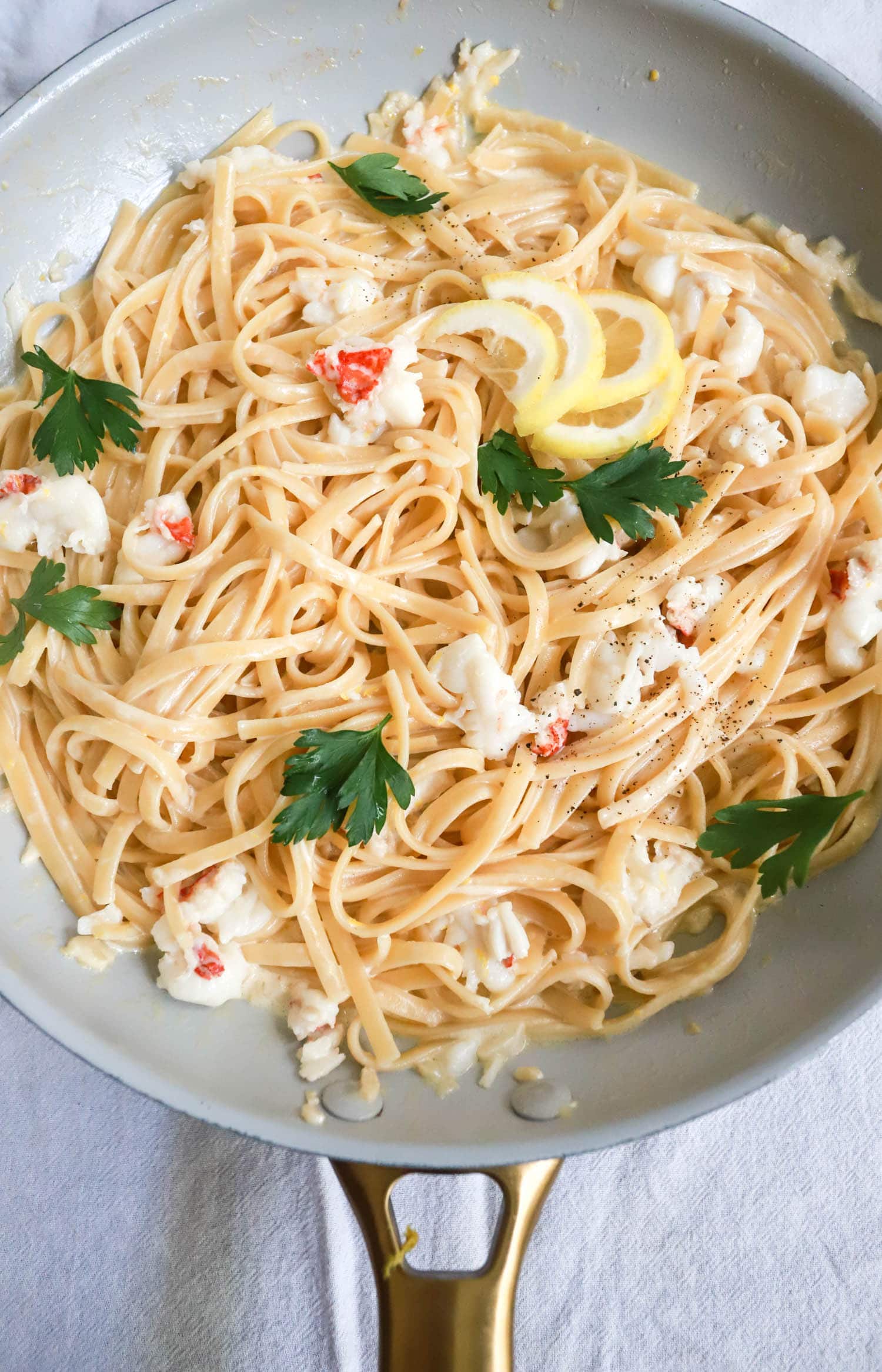 Skillet of lobster with pasta and lemon.