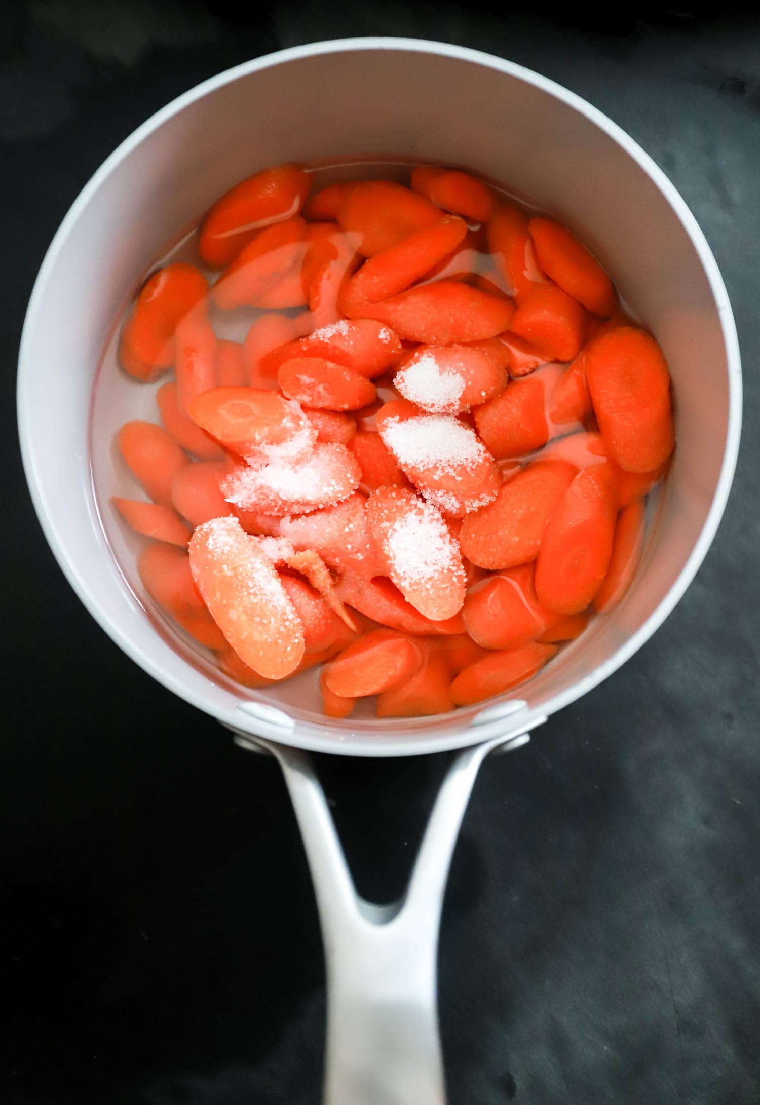 carrots with salt and sugar in a small pot.