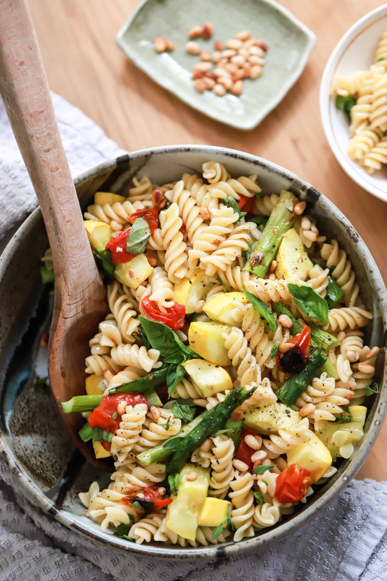 bowl of pasta salad with veggies and wooden spoon