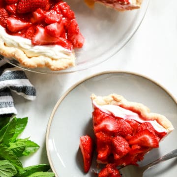 flatlay strawberry pie with cream cheese slice on plate with bite taken out