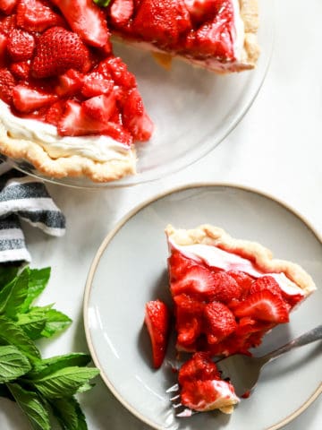 flatlay strawberry pie with cream cheese slice on plate with bite taken out