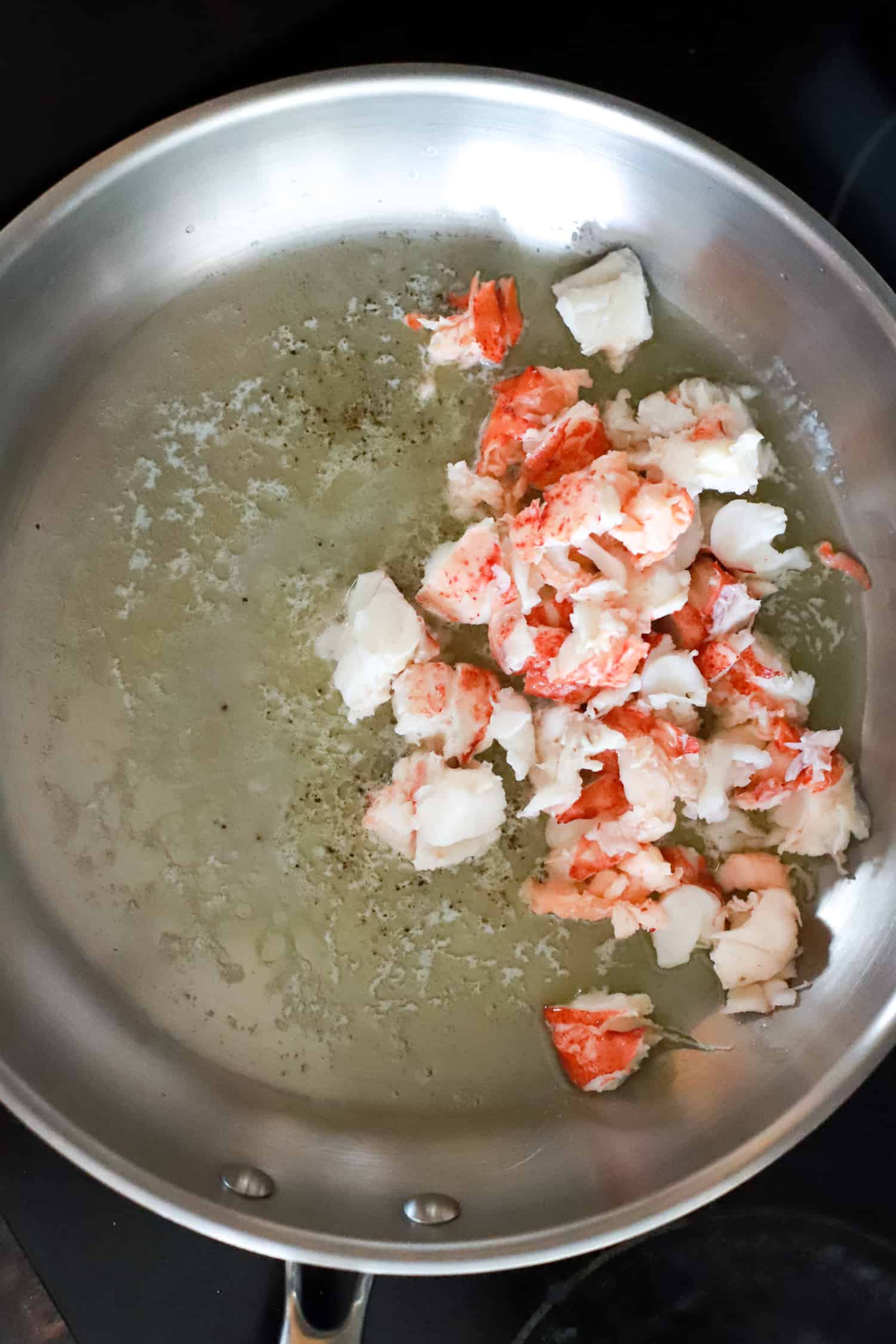 fresh lobster chunks in skillet with butter