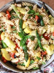 large serving bowl of vegan pasta salad with asparagus and tomatoes