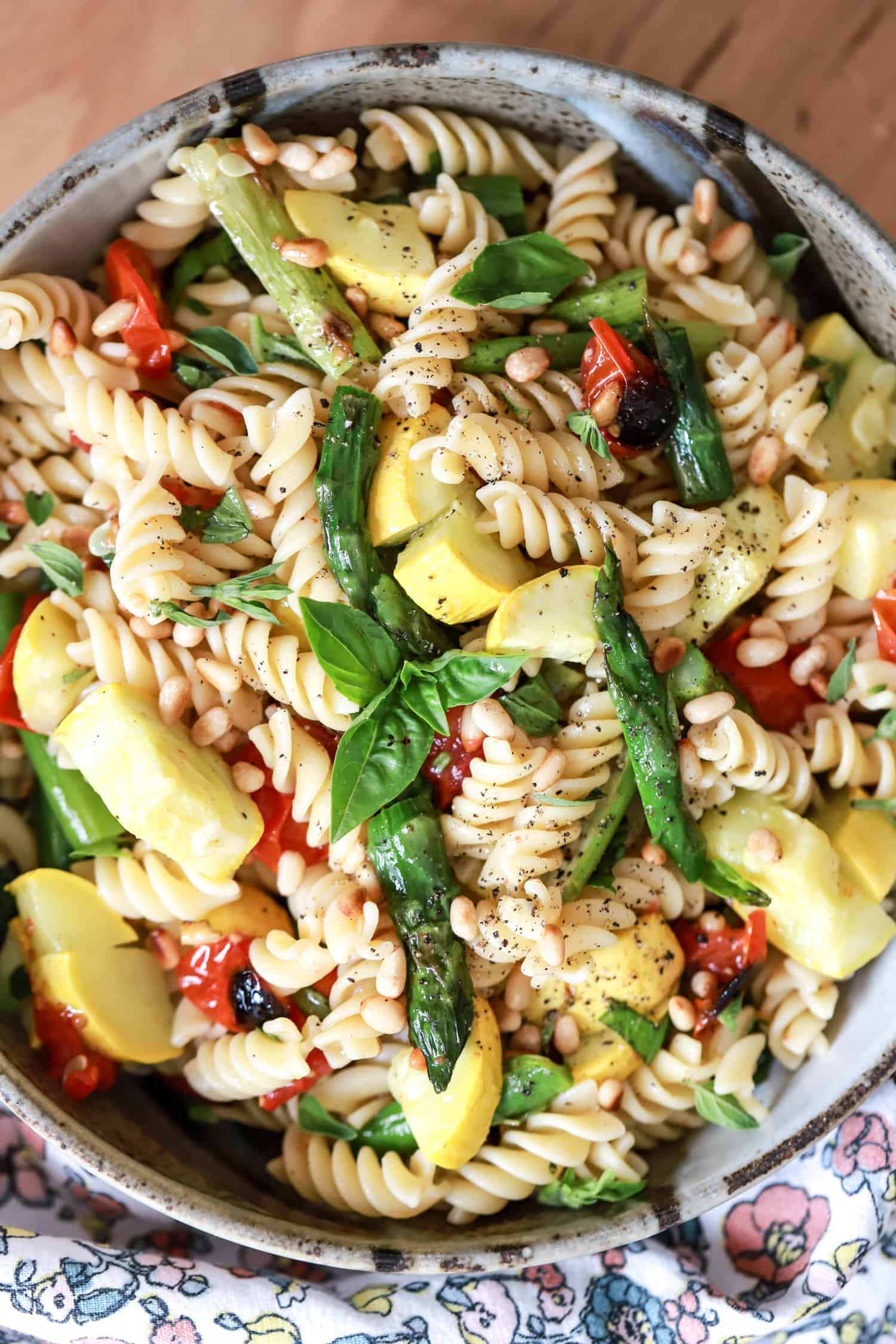 large serving bowl of vegan pasta salad with asparagus and tomatoes