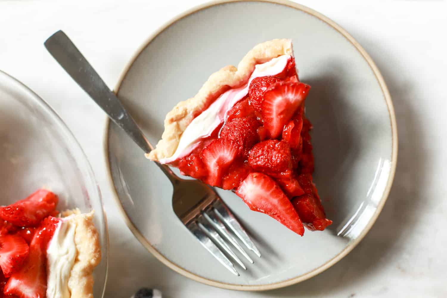 single slice of cream cheese strawberry pie with plate and fork