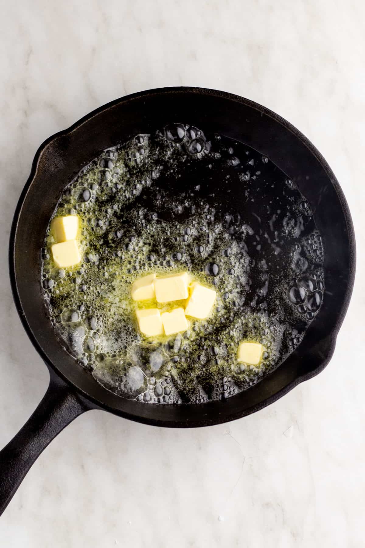 Butter melting in hot cast iron skillet.