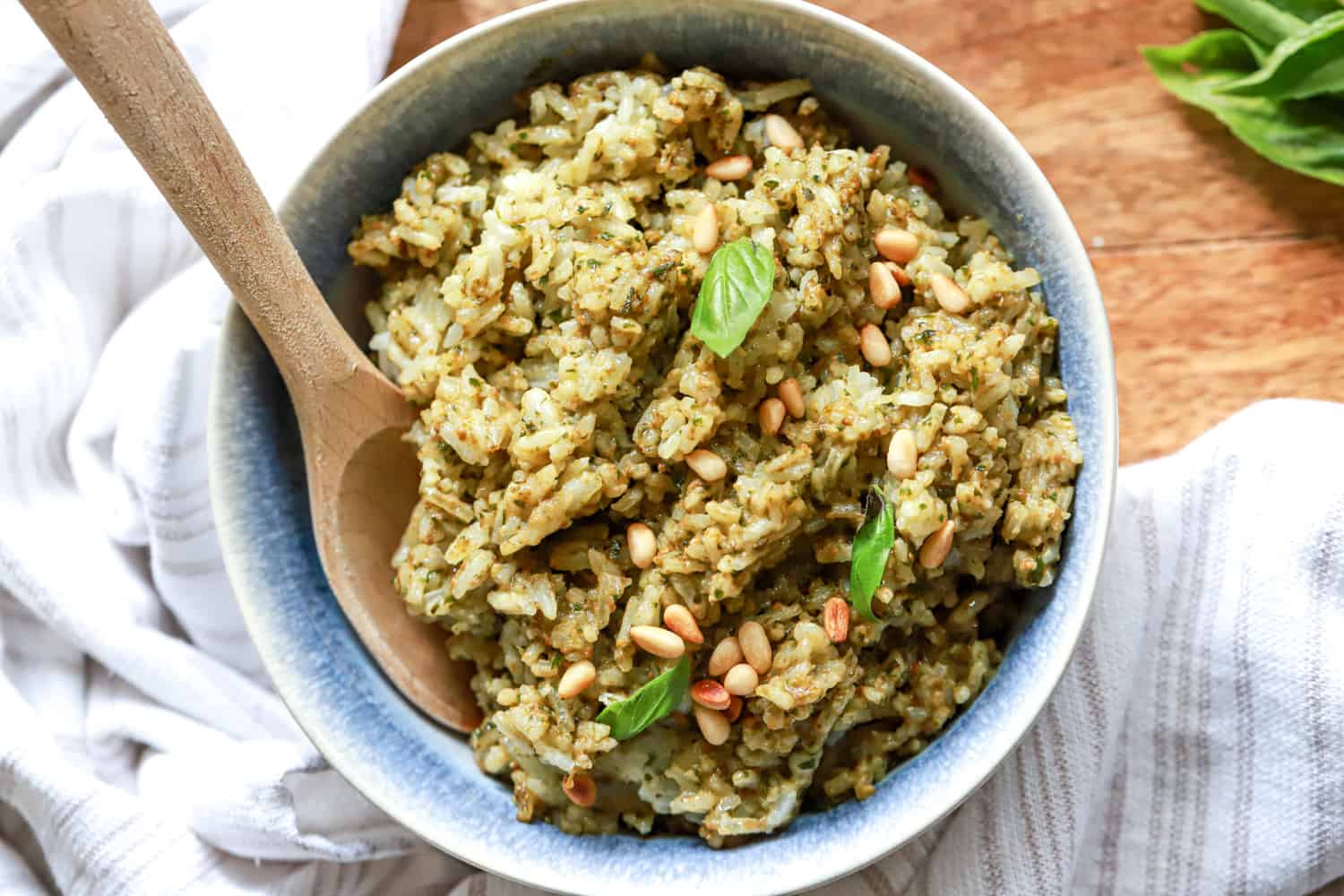 pesto rice in bowl with wooden spoon