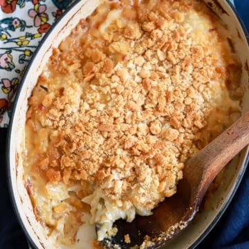 sweet onion casserole with wooden spoon and floral napkin in background.