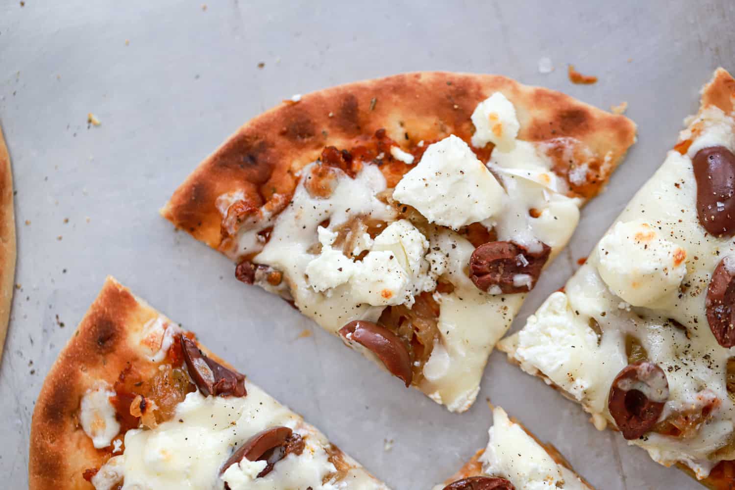 close up triangle wedge of goat cheese flatbread.