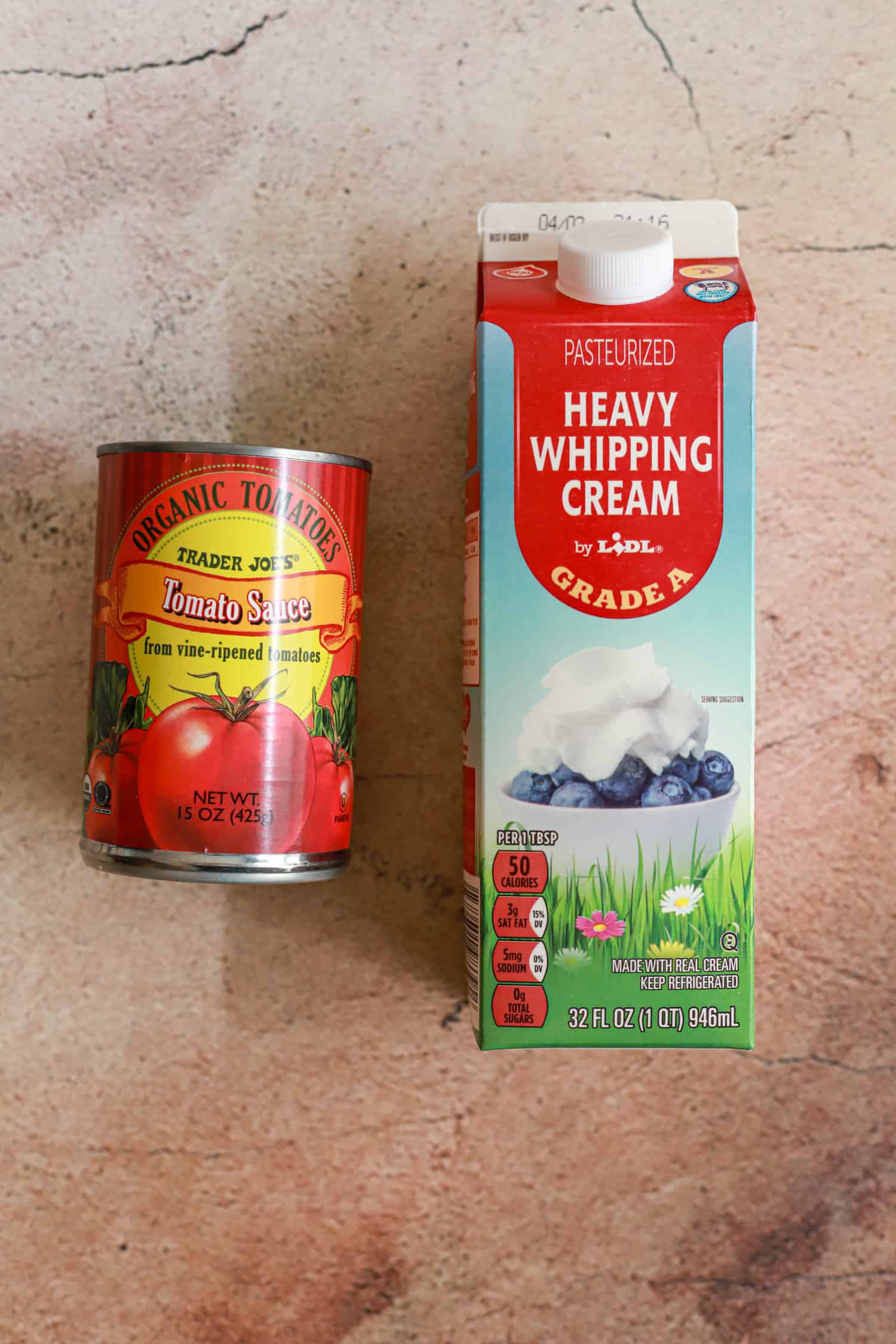 carton of heavy whipping cream and can of tomato sauce.