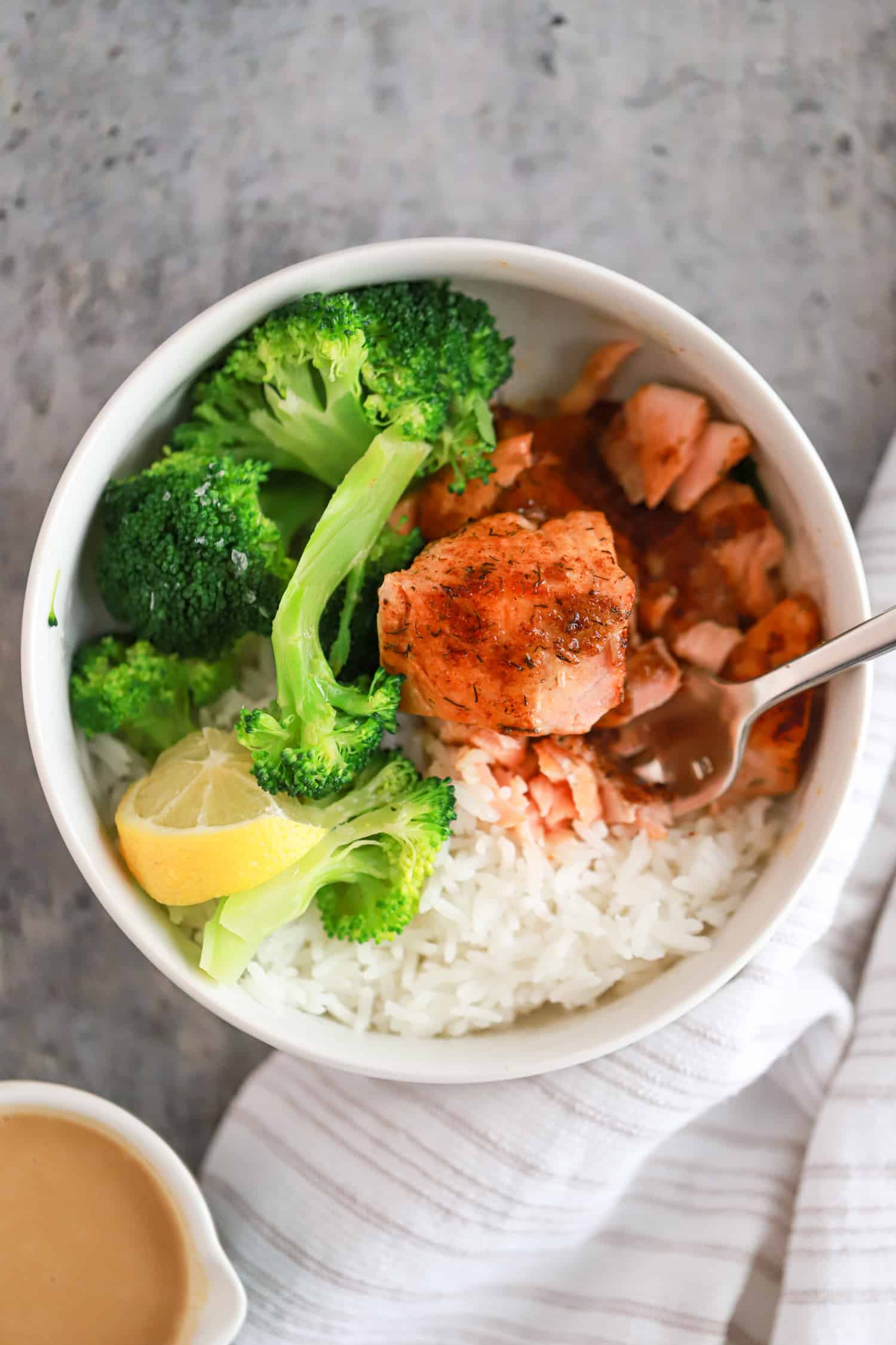 white bowl with blackened salmon, rice, and broccoli