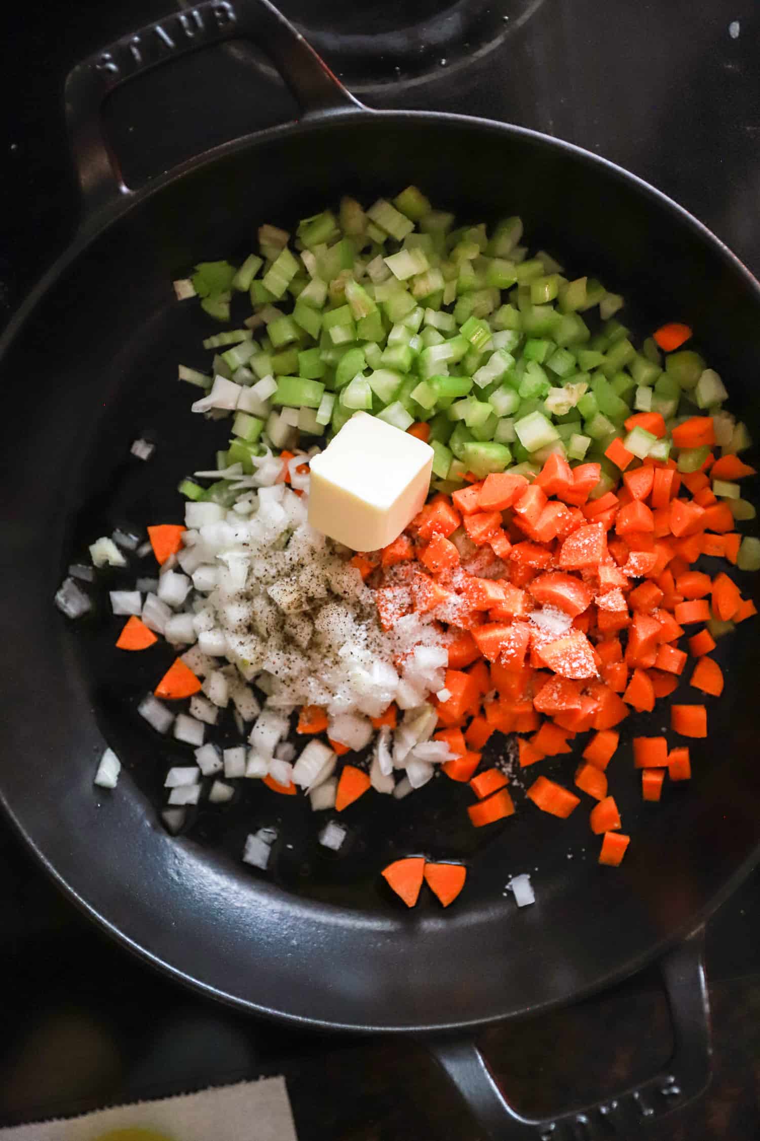 butter with chopped veggies in large black skillet.