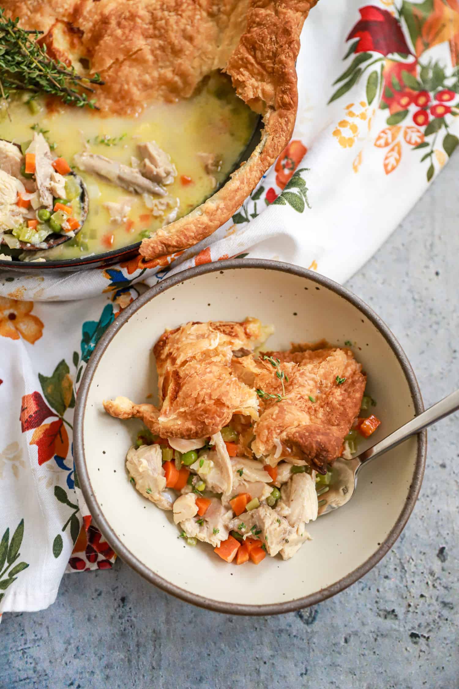 pottery bowl of turkey pot pie with floral napkin.