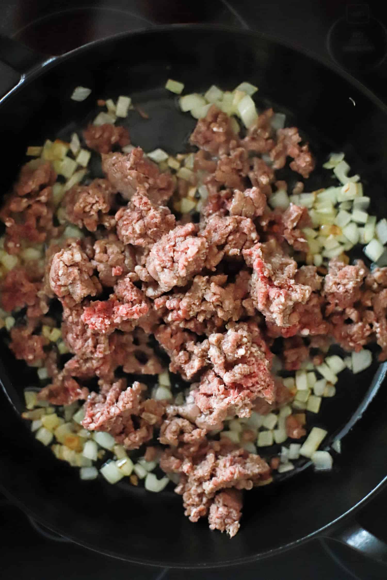 Ground beef crumbled in a skillet.