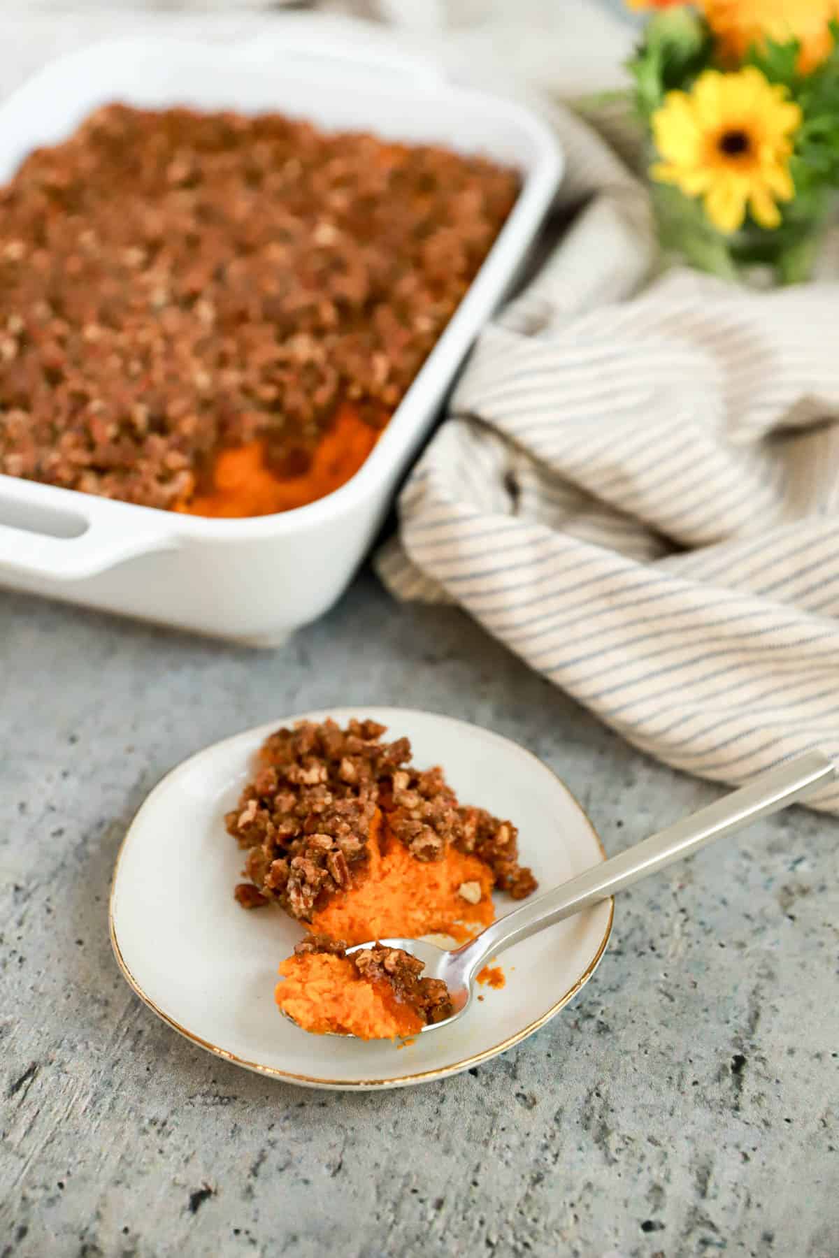 Small plate of carrot soufle on gray speckled background.